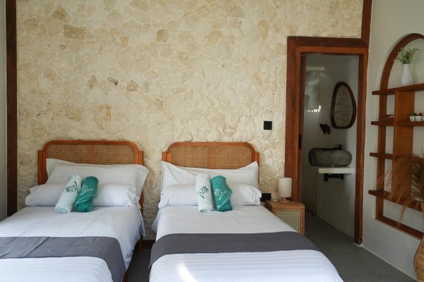 Habitación con dos camas individuales y estanterías en Ombara Resort Mentawai