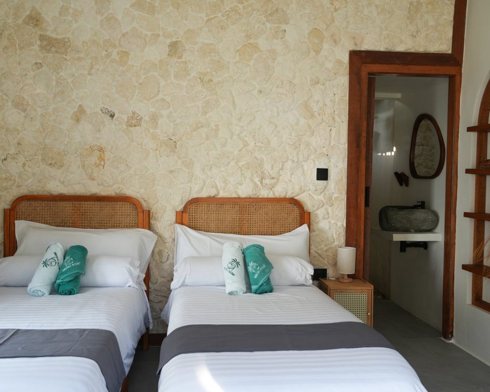 Habitación con dos camas individuales y estanterías en Ombara Resort Mentawai
