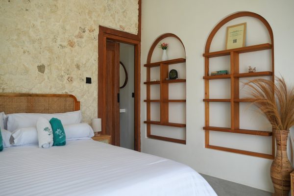 Habitación con cama doble y estanterías de madera en Ombara Resort Mentawai