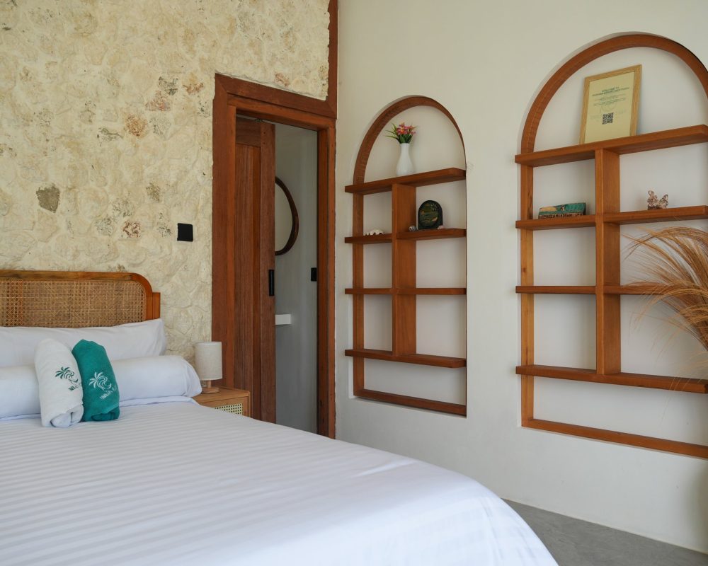 Habitación con cama doble y estanterías de madera en Ombara Resort Mentawai